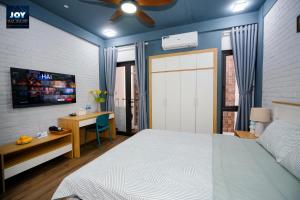 a bedroom with a bed and a desk and a door at JOY APARTMENT TAY HO in Hanoi