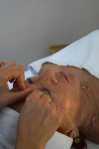 a man laying on a bed with his hands on his face at Hôtel & Espace Bien-être La Maison du Lierre in Biarritz