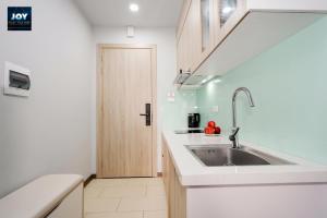 a white kitchen with a sink and a door at JOY APARTMENT TAY HO in Hanoi +100 photos