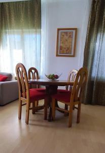 a dining room table with chairs and a bowl of fruit on it at Apartman 77 in Požarevac
