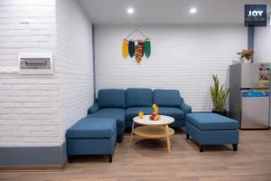 - une salle d'attente avec des chaises bleues et une table dans l'établissement JOY APARTMENT TAY HO, à Hanoï