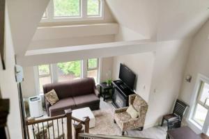 a living room with a couch and a tv at 3BR Lakeside Dream Penthouse with Roof Deck Views in Harrison Hot Springs