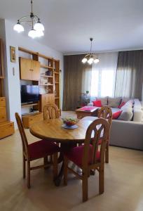 a living room with a table and chairs and a couch at Apartman 77 in Požarevac