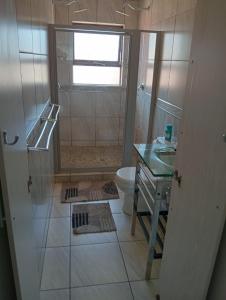 y baño con ducha, aseo y lavamanos. en Flip-Flops, en Jeffreys Bay