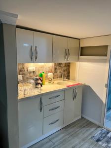 a kitchen with white cabinets and a sink at Müstakil Alt Kat Havuzlu Villa in Erdemli