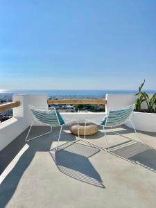 two chairs and a table on a balcony with the ocean at Vima Santorini, Traditional Luxury in Emporio