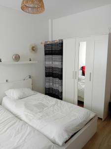 a bedroom with a white bed and a mirror at Centre ville d'Amelie les bains in Amélie-les-Bains-Palalda
