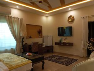 拉合爾的住宿－Hotel Luxe Heights Lahore，一间带床和电视的客厅