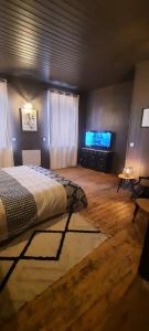 Maison de ville cosy في Kergrist: غرفة نوم بسرير وتلفزيون بشاشة مسطحة