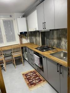 a kitchen with white cabinets and a sink and a stove at Apartament ultracentral Botis in Sighetu Marmaţiei