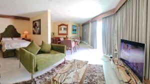 uma sala de estar com um sofá, uma televisão e uma cama em Breakfast at Monaco - Palais Boracay em Boracay