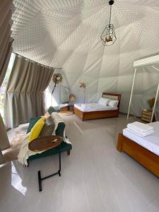 Cette chambre comprend 2 lits et un plafond. dans l'établissement Boho Farm Glamp, à Santo Tomas