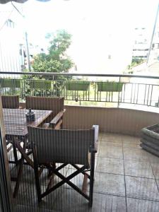 a balcony with a table and a bench on a balcony at Home Sweet Home! in Volos