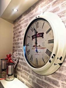a large clock hanging on a brick wall at Home Sweet Home! in Volos