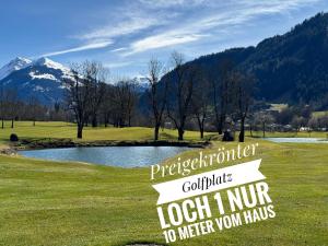 a sign for a golf course with a pond and mountains at TURM KAPS Luxury home direkt am Golfplatz by Belle Stay in Kitzbühel