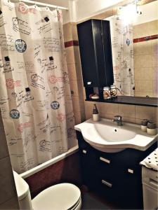 a bathroom with a sink and a toilet and a shower curtain at Home Sweet Home! in Volos