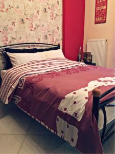 Una cama con una manta roja y blanca. en Home Sweet Home!, en Volos