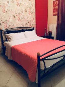 1 cama con manta roja y almohadas blancas en Home Sweet Home!, en Volos