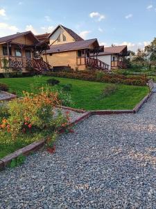 a house with a gravel driveway in front of a yard at Baltina Parc Transfagarasan in Curtea de Argeş