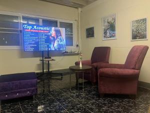 a waiting room with two chairs and a tv at At Home Phetchaboon in Phetchabun