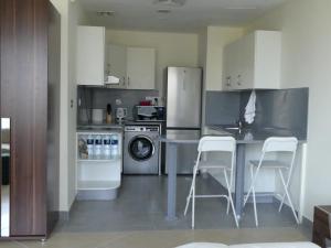 a kitchen with a refrigerator and a table and chairs at Stargazers cozy apartment with direct Metro access in Dubai