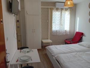 a room with two beds and a table and a tv at Centre ville d'Amelie les bains in Amélie-les-Bains-Palalda