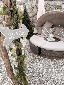 a backyard with a beach sign and a couch at Gästewohnung am See in Neuenkirchen