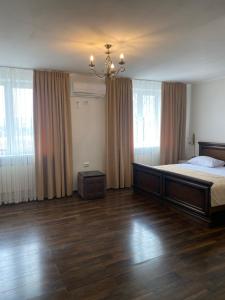 ein Schlafzimmer mit einem großen Bett und einem Kronleuchter in der Unterkunft Едем in Brzezhany
