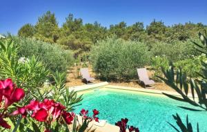 een zwembad in een tuin met rode bloemen bij Li Vue Vent in Saint-Rémy-de-Provence