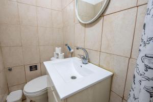 een badkamer met een wastafel, een toilet en een spiegel bij Godson down town in Haifa