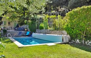 une piscine dans une cour avec une fontaine dans l'établissement Le Mas Des Oiseaux, à Vaison-la-Romaine