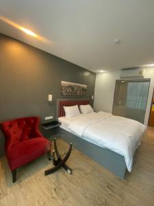 1 dormitorio con 1 cama y 1 silla roja en 8 Hotel & cafe en Bangkok