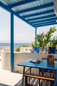 una mesa azul en un patio con vistas al océano en Iliovasilema VILLAGE, en Donoussa