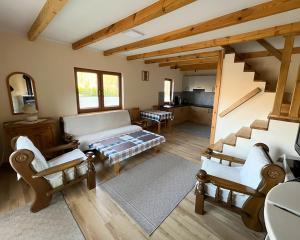 a living room with a couch and chairs and a staircase at Winnica Sielskie Kresy in Michałowo