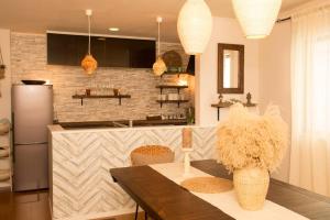 a kitchen with a table and a refrigerator at ライカムまで10分!!大人女子にオススメ。フォトジェニックなアンティーク家具に囲まれて最高の夜を。。 in Awase