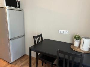 a kitchen with a black table and a refrigerator at Imantas apartment in Daugavpils