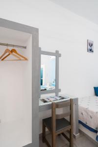 a bedroom with a desk with a mirror and a bed at Iliovasilema VILLAGE in Donoussa