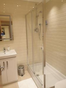 La salle de bains est pourvue d'une douche et d'un lavabo. dans l'établissement London Luxury 2 bedroom flat 4 mins to Ilford Stn Sleeps x8 Free Parking, à Ilford