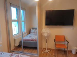 a room with a mirror and a tv and a chair at London Luxury 2 bedroom flat 4 mins to Ilford Stn Sleeps x8 Free Parking in Ilford