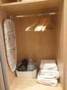 a closet with white towels and a rack with hangers at London Luxury 2 bedroom flat 4 mins to Ilford Stn Sleeps x8 Free Parking in Ilford