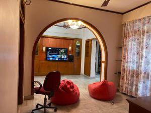 an archway in a room with red chairs and a television at South-East-West Facing 3 BHK Lakeview Flat Howrah West Bengal in Howrah