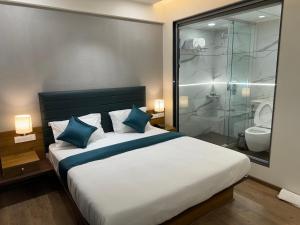 HOTEL CITADELL DE DAMAN في دامان: غرفة نوم بسرير كبير ودش زجاجي