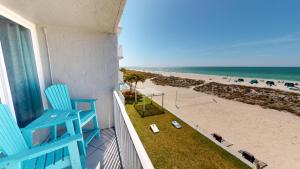 uma varanda com uma cadeira azul e a praia em Island Inn Beach Resort em St Pete Beach