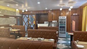 達曼的住宿－HOTEL CITADELL DE DAMAN，一间带棕色桌椅的餐厅和一间厨房