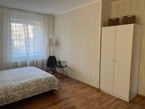 ein Schlafzimmer mit einem Bett, einem Schrank und einem Fenster in der Unterkunft Imantas apartment in Daugavpils