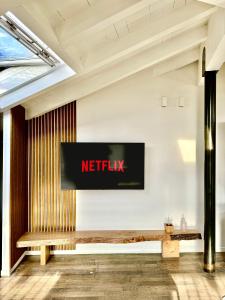 a netflix sign on a wall with a bench at BRIDGE Apt Brescia - Netflix - wifi in Brescia +15 photos