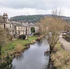 a river in a small town with houses and buildings at Peaceful Getaway In Peebles in Peebles +21 photos
