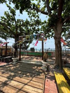 un parc avec un arbre et un banc jaune dans l'établissement Generosa Resort, à Bauang