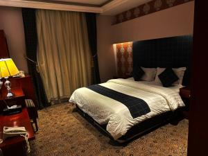 a bedroom with a large bed in a room at بنان فال للشقق المخدومة in Hafr Al Baten