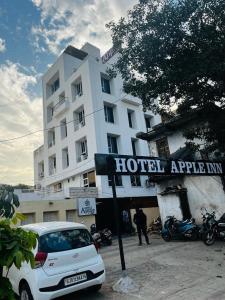 um carro branco estacionado em frente a um hotel em Hotel Apple Inn em Ahmedabad